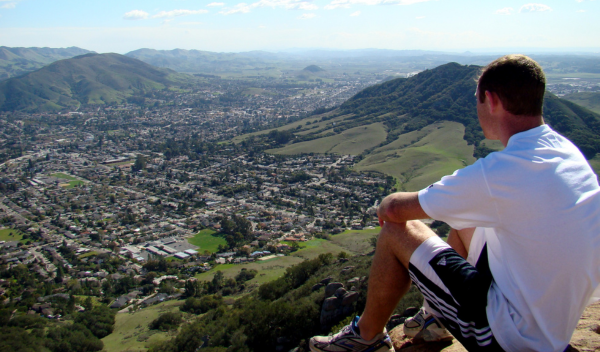 man sitting on mountain in San Luis Obispo after hiking