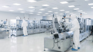 Sterile High Precision Manufacturing Laboratory where two Scientists in protective coveralls turn on machinery
