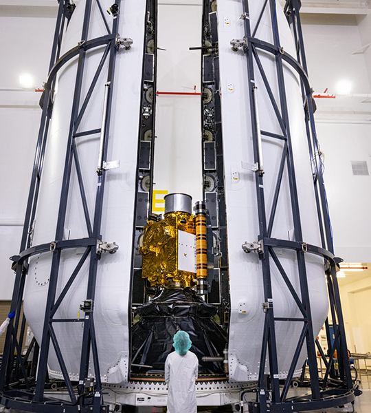aerospace worker in front of rocket fairing