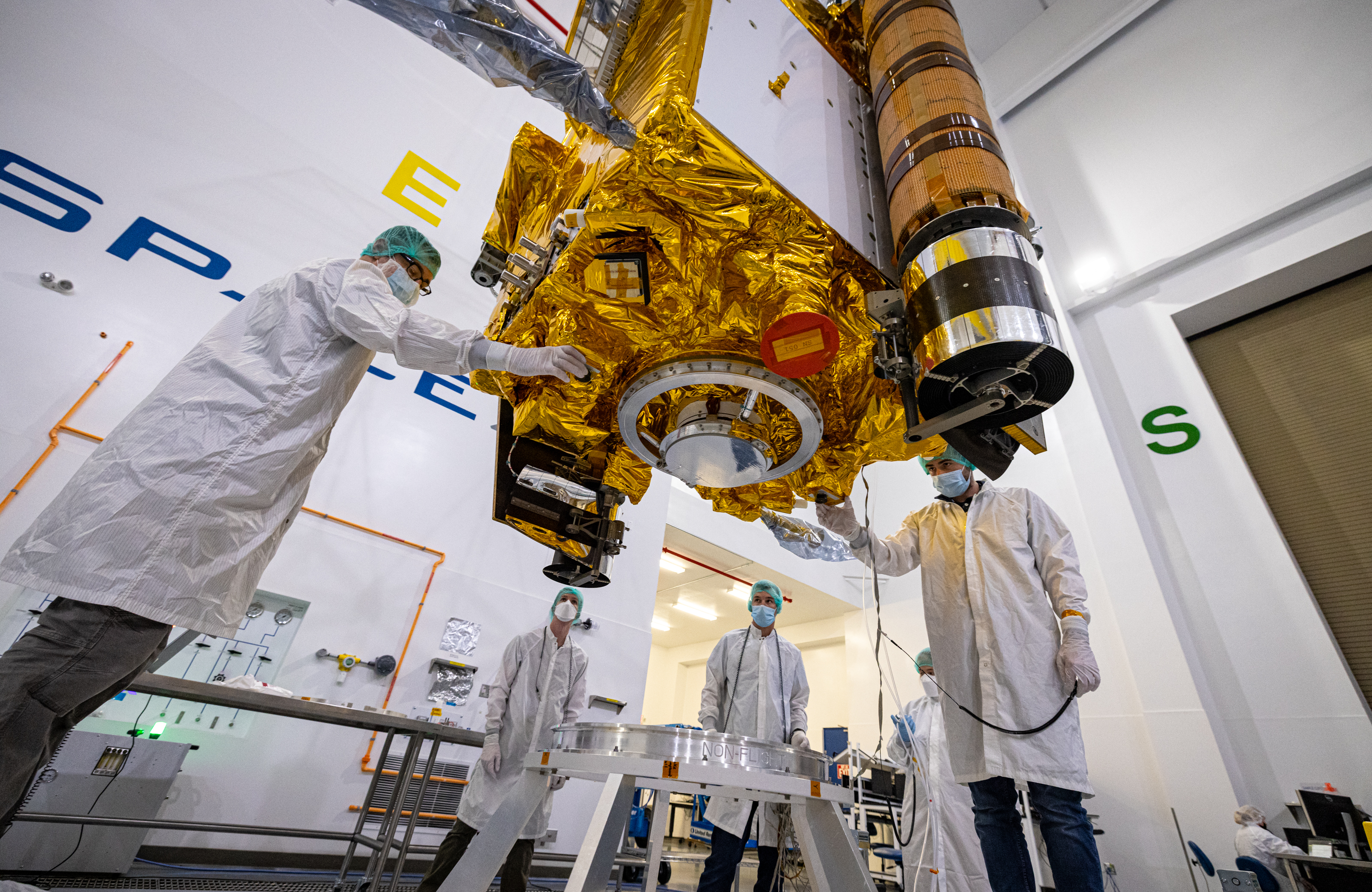 technicians preparing a space payload