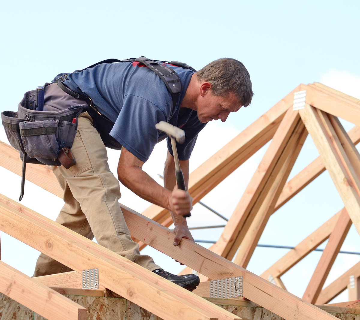 Carpenter hammering on a roof