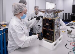 Systems engineer takes dimension measurements of the CAPSTONE spacecraft at Tyvak Nano-Satellite Systems, Inc.